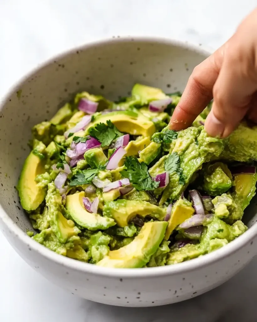 u6472731739 Hand mashing ripe avocado with red onion and lime 422423e3 b4e8 414e a5ed 11a468ecbcd7 2 Fresh Shrimp and Guacamole Cups