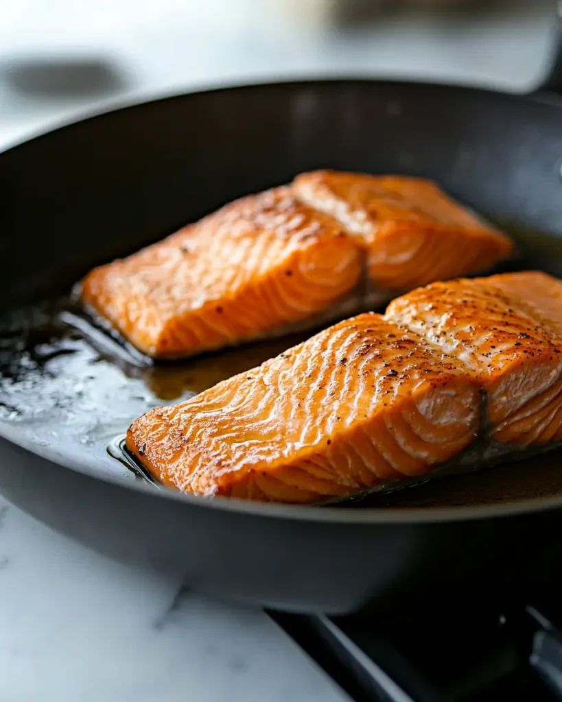 u6472731739 Salmon fillets searing in a skillet with golden c 0996e9c2 af9b 4a95 b4fe 49e2485976a2 2 Creamy Coconut Salmon Curry